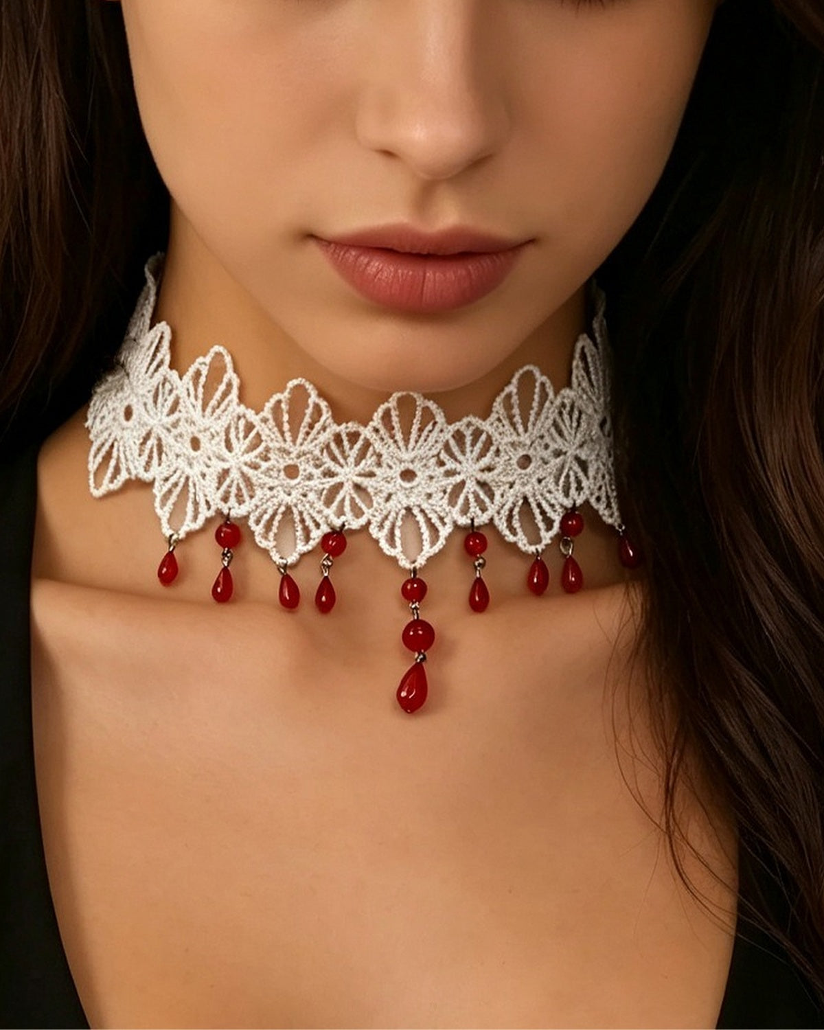 Choker en dentelle blanche à pampilles rouges porté avec un haut noir